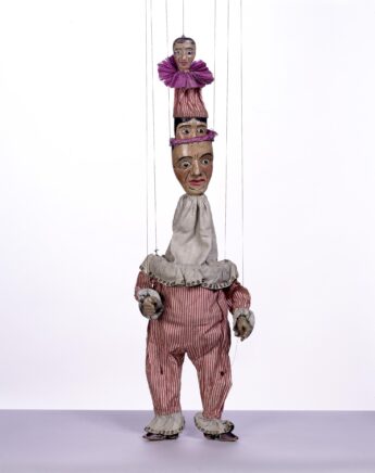 Marionnettes à fils d'un clown, la tête d'un deuxième clown sort de sa tête, et un autre personnage de la tête du deuxième clown