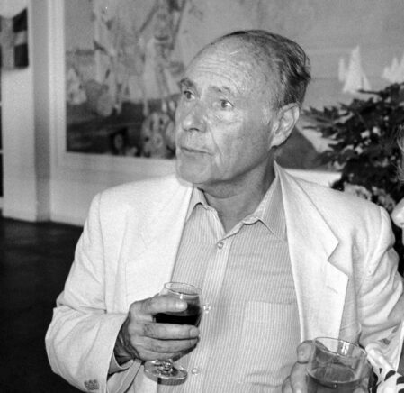 Portrait photographique de l'écrivain tenant un verre de vin