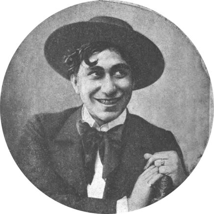 Portrait photographique d'un homme souriant, coiffé d'un chapeau