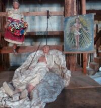 Marionnette d'une femme portant une corbeille de fleurs, d'un homme couché dans un lit et image de son âme sous la forme d'un homme vêtu d'un pagne.