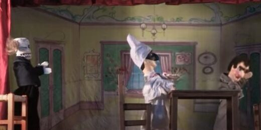 Trois marionnettes à gaine en scène, dont Pulcinella et un personnage ayant une tête de mort